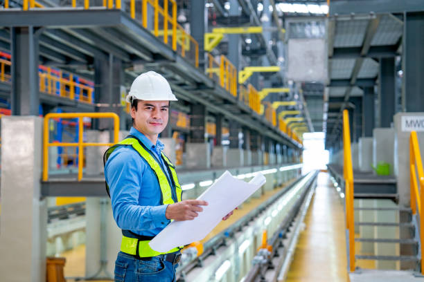 istock Professional engineer hold construction chart or plan and look at camera in electrical or sky train factory workplace. 1758402590
