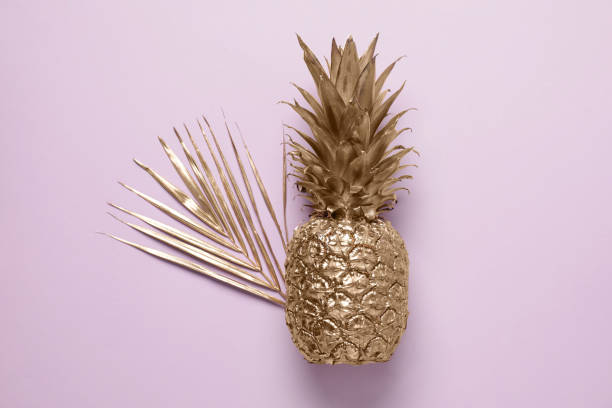istock Golden pineapple and palm leaf on pink background, top view 1758414091