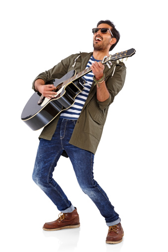Full length portrait of a happy guy playing a guitar over white background