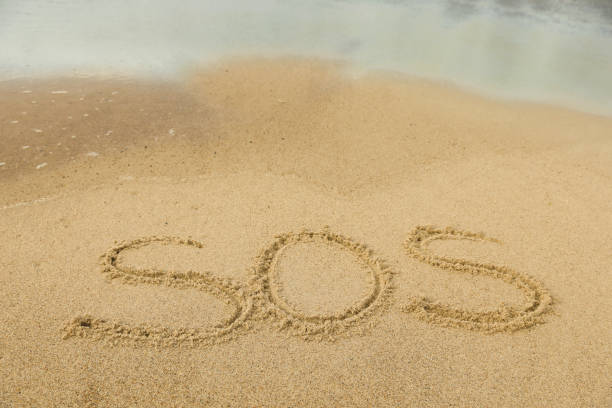 istock Message SOS drawn on sand near sea 1758441689