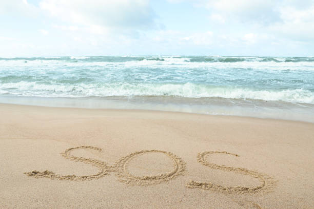 istock Message SOS drawn on sand near wavy sea 1758446119