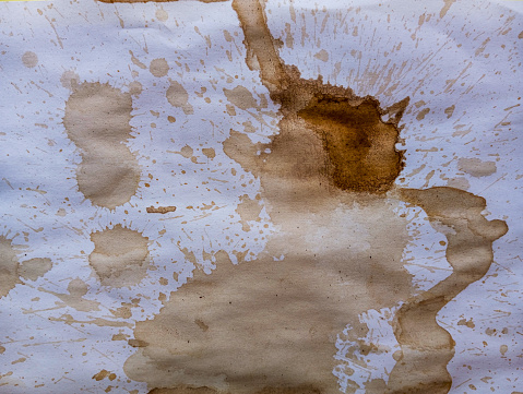 Dirty white paper with brown coffee stains. Coffee drops and splash on white paper.
