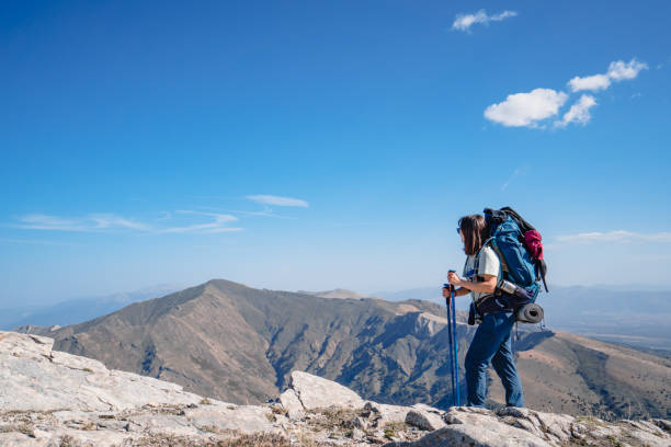istock Female mountain climber is looking at the scenery  while  standing on the summit of a mountain. 1758448264
