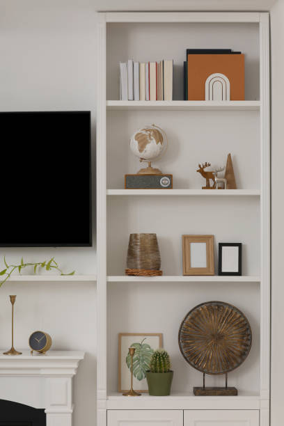 istock Stylish shelves with different decor elements and TV set in room. Interior design 1758449410