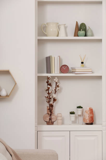 istock Stylish shelves with decorative elements and houseplants near white wall. Interior design 1758451090