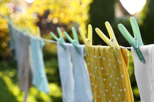 Clean clothes drying in garden, focus on clothespin
