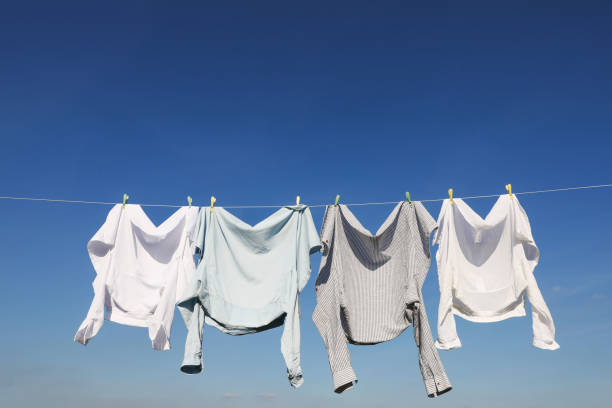 istock Washing line with drying clothes and clothespins under blue sky, space for text 1758488643