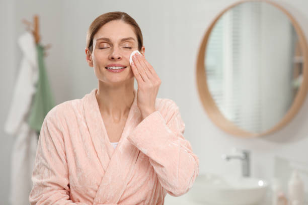 istock Beautiful woman removing makeup with cotton pad indoors, space for text 1758490913