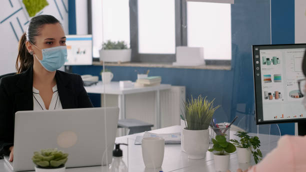 istock Freelancers wearing protective face masks working on computer in business office 1758511706