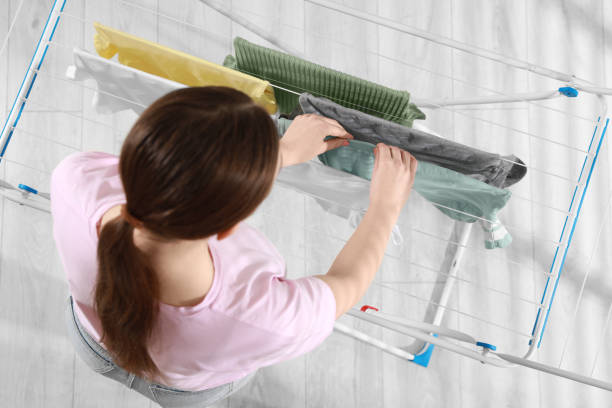 istock Woman hanging different apparel on clothes airer, top view 1758512767