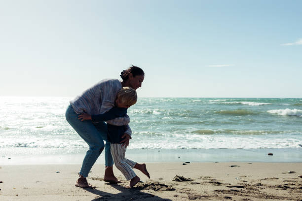 istock Mom is hugging her three-year-old son on the seashore. 1758513384