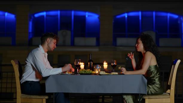 istock Camera approaching happy elegant couple sitting at decorated table with candles outdoor eating on romantic date. Anniversary celebration. Slow motion. Romantic date. Family concept 1758530016
