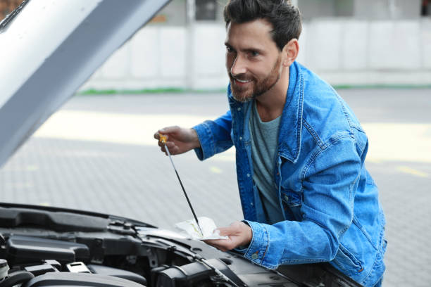 istock Man checking motor oil level with dipstick outdoors 1758532170