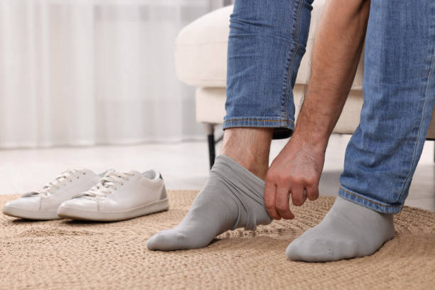 istock Man putting on grey socks at home, closeup 1758532717