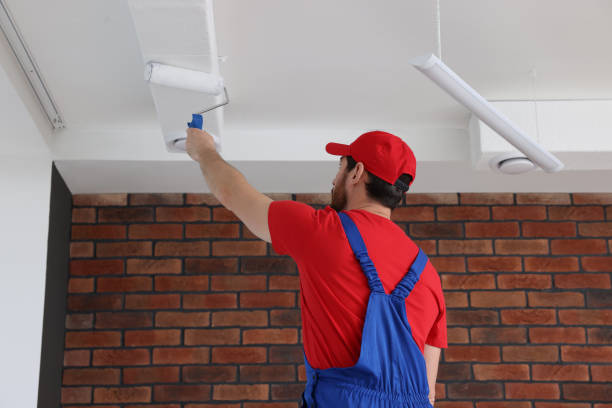 istock Handyman painting ceiling with roller in room, back view 1758533240