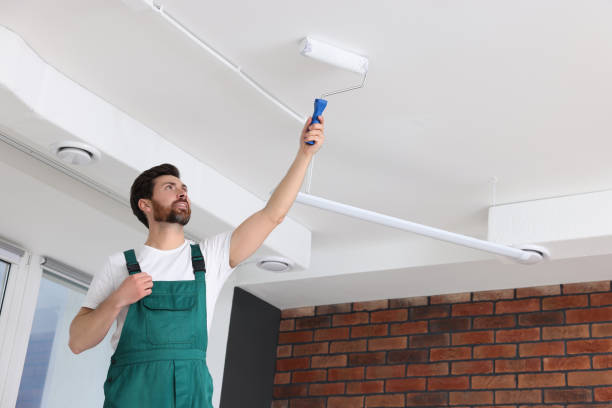istock Handyman painting ceiling with roller in room 1758534288