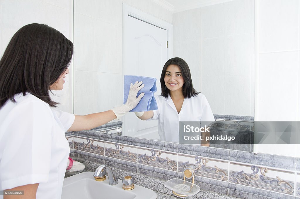 Pretty woman cleans  mirror in bathroom at home Adult Stock Photo