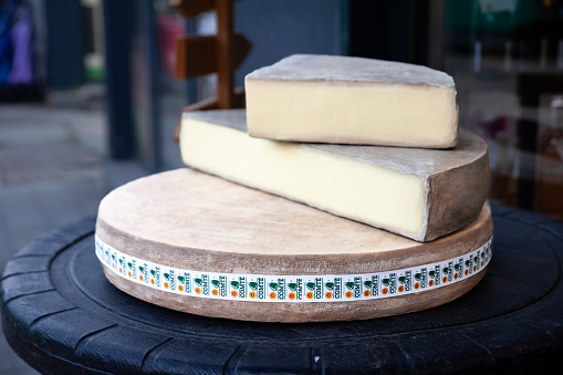 Picture of a wheel of Comte cheese sliced and ready for sale in Belgrade. Serbia. Comté is a French cheese made from unpasteurized cow's milk in the Franche-Comté traditional province of eastern France.