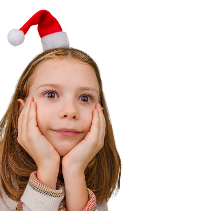 Cute child girl in Santa hat white background. Happy holidays and New Year