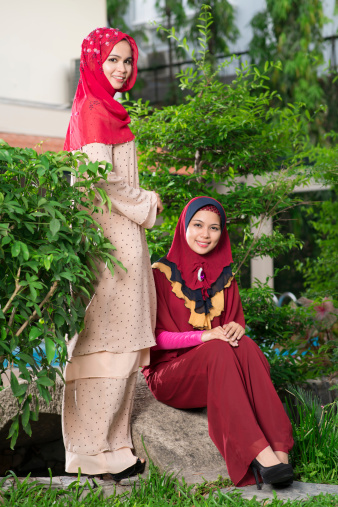 Full-length portrait of fashion muslim women in traditional abaya dresses outside