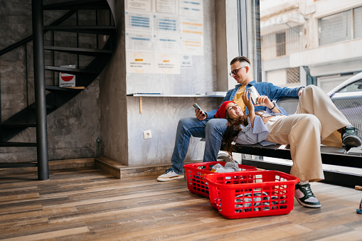 Young couple enjoying their time together while waiting for the laundromat