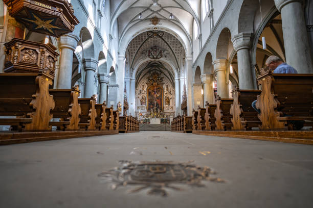 Description: Metal inscription and ornaments on the bottom of the brightly lit Romanesque three-nave columned basilica. Minster (Münster Unserer Lieben Frau Konstanz), Lake Constance (Bodensee), Baden-Württemberg, Germany. inscripción y adornos metálicos en la parte inferior de la basílica románica con columnas de tres naves, brillantemente iluminada. catedral (münster unserer lieben frau konstanz), lago de constanza (bodensee), baden-württemberg, alemania.