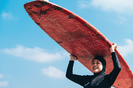 muslim woman  preparing to go surfing at dawn