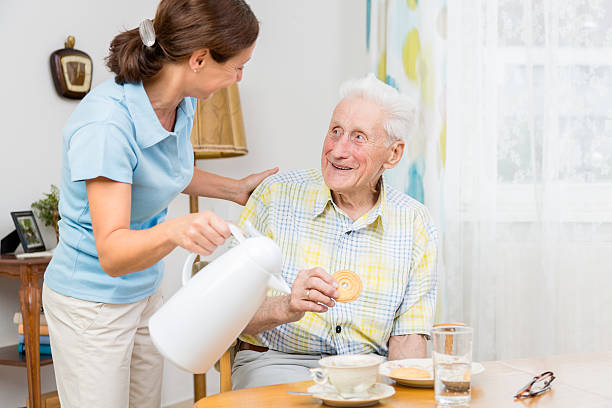 prestador com homem idoso - senior adult nursing home eating home interior imagens e fotografias de stock