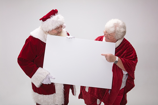 Mr. & Mrs. Santa Claus looking at a blank sign