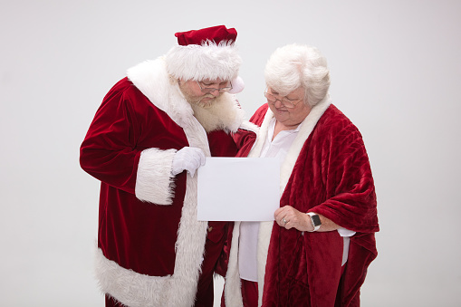 Mr. & Mrs. Santa Claus looking at a blank sign