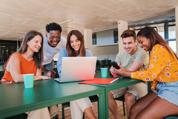 istock Group of multicultural teenage students working on a project using a laptop computer on a high school library. Young friends studying on a university class. Academic team learning doing the homework 1758717114