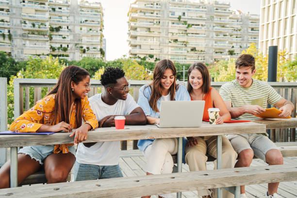 istock Smiling multiracial students searching on internet and watching funny videos at the university campus. Happy and positive group of young friends laughing and sharing content on the social media online outdoors. Education concept 1758719751