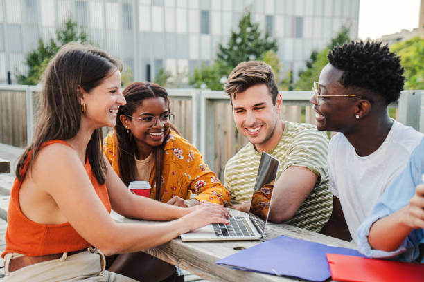 istock Multiethnic group of happy and smiling young students preparing an exam and doing homeworks, sharing different ideas using their laptops in positive and friendly communication on campus. Education concept 1758727018