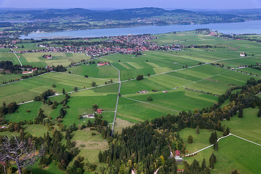 Aerial drone view valley, fields, village, lake at foot of Alpine mountains in Bavaria, Germany