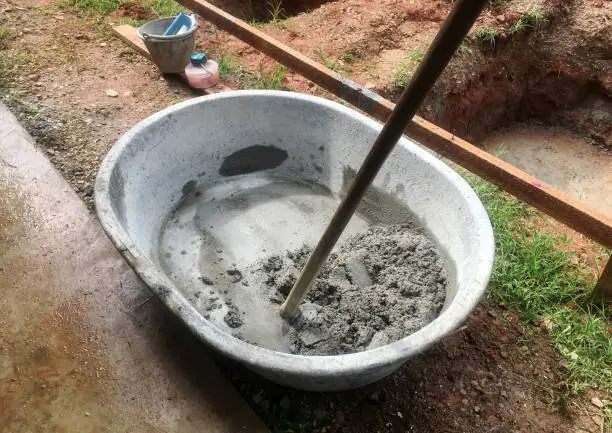 The mixing of stone, cement, sand together to make a strong concrete floor.