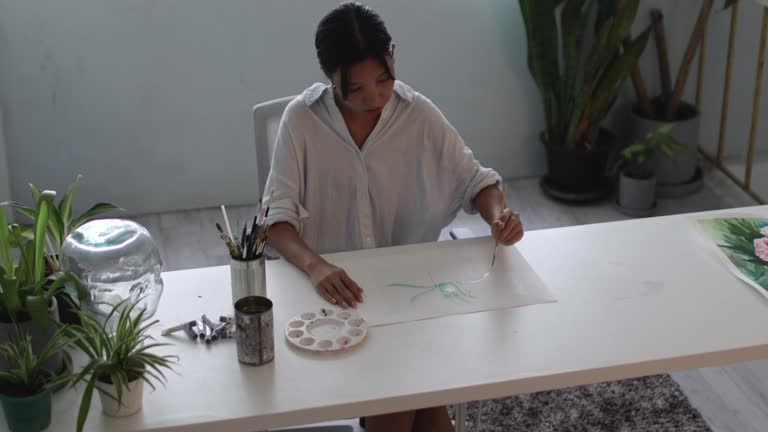 Woman Painting Watercolor Plants In Home Studio - stock photo