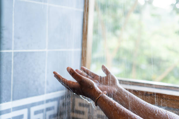 istock A woman's hands in a watering can with nature in the background. 1758814220