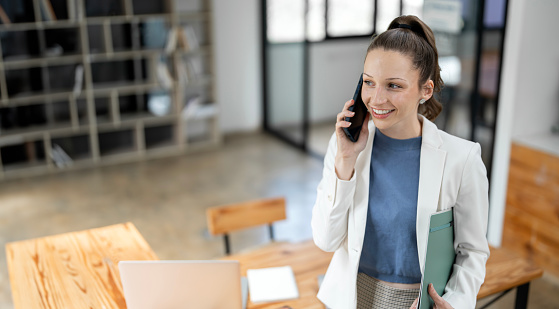 Smiling businesswoman using her phone in the office.