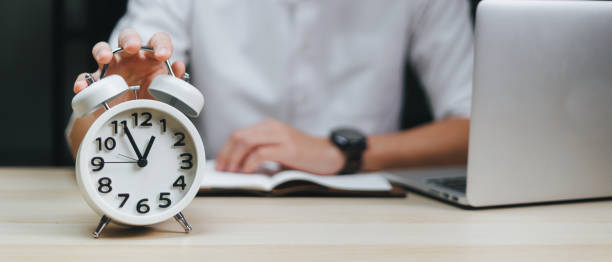 istock Employees work overtime until late and put their hands on the clock. 1758862641