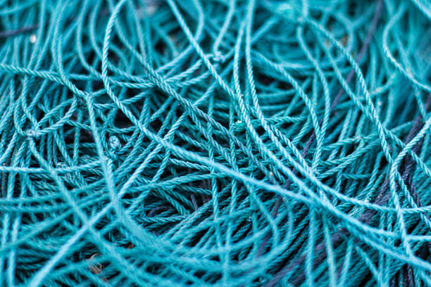 primer plano de una red de pesca enredada - commercial fishing net netting fishing striped fotografías e imágenes de stock