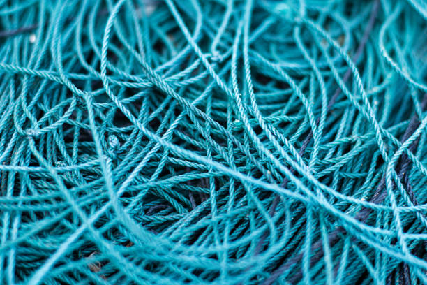 primo piano di una rete da pesca aggrovigliata - commercial fishing net netting fishing striped foto e immagini stock