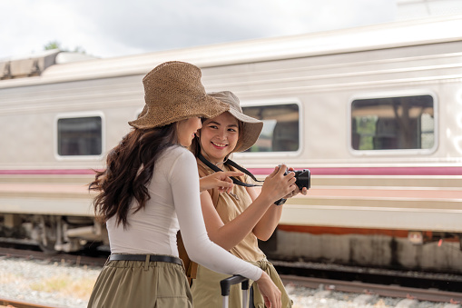 Two young female traveler on the train station, Travel lifestyle and seasonal vacation concept.