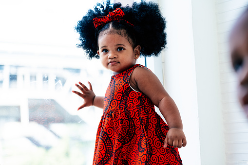 Cute little baby African girl playing in home