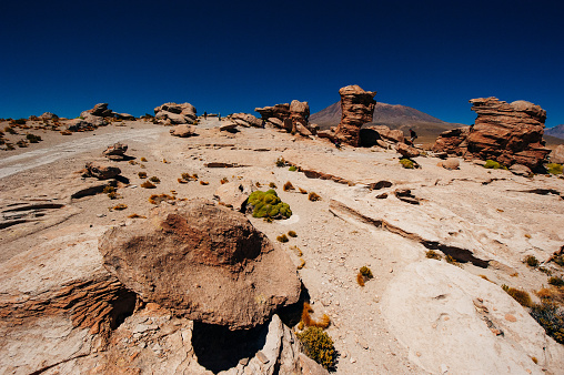 reddish rock formations in desert morning sun, bolivia.