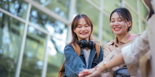 istock Happy females university student chat holding hands sincerely with each other after class. guy and girls wear casual clothes to university study. university College and University life concept 1758932862