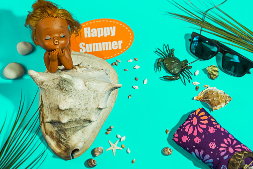 Summer holiday design with tropical beach background. Cute tanning doll in large seashells, sunglasses and beach sarong. Concept of summer holiday and sale.