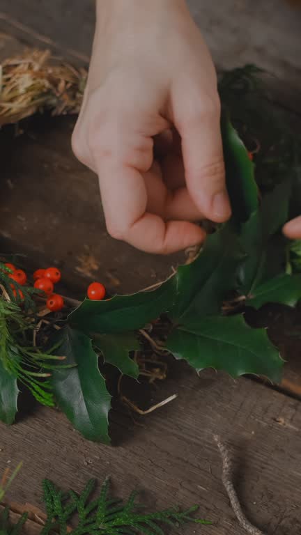 Vertical video. Hands making Christmas wreath. Eco friendly craft small business