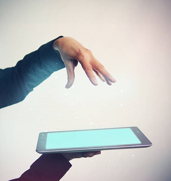 istock Hand Magically Summons Glowing Particles from Tablet 175899469