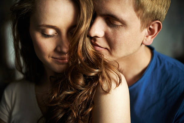 A young romantic couple in bliss Young man enjoying smell of hair of his sweetheart scented stock pictures, royalty-free photos & images