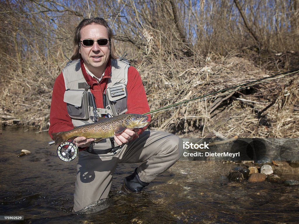 Flyfisherman impugnando una Trota comune - Foto stock royalty-free di Acqua